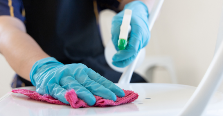 person sanitizing chair using gloves